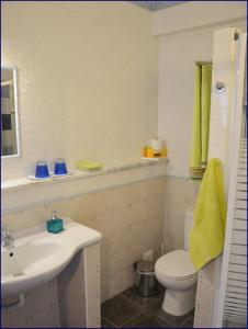 a white bathroom with a sink and a toilet at Studio Casa Formosa in Olhão