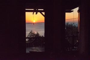 a sunset seen through the windows of a house at House of the Rising Sun in Chorefto