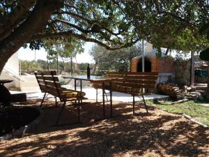 una mesa de picnic y dos sillas bajo un árbol en Hvar Mediterranean Ranch House, en Stari Grad