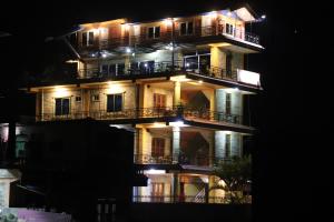 Rānīpauwa的住宿－Hotel Young's Stupa，一座高大的建筑,晚上带阳台
