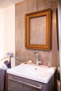 a bathroom with a white sink and a mirror at Zimmer Und Aussicht in Friedrichstadt