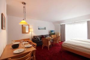 ein Hotelzimmer mit einem Bett und einem Esszimmer in der Unterkunft Villa Bellevue Premium by Rujana in Binz