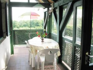 ein Tisch mit Stühlen und ein Sonnenschirm auf einer Veranda in der Unterkunft Panorámás nyaraló Badacsonyörsön in Badacsonytomaj