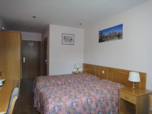 una camera d'albergo con letto, comodino e letto sidx sidx. di Hotel DenRiKo a Heidelberg