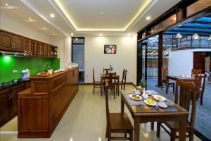 ein Restaurant mit Holztischen und -stühlen und einer Bar in der Unterkunft Threeway Riverside Villa in Hoi An