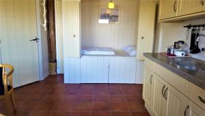 a kitchen with white cabinets and a counter top at De Koevoet in Teroele