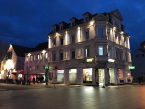 un grand bâtiment situé dans une rue de la ville la nuit dans l'établissement Unterkunft Göppingen, à Göppingen