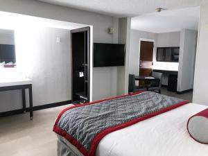 um quarto de hotel com uma cama e uma televisão em Ramada by Wyndham Suites Orlando Airport em Orlando