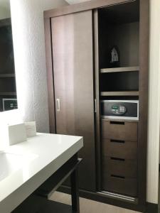a kitchen with a counter and a cabinet with a microwave at Ramada by Wyndham Suites Orlando Airport in Orlando