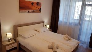 a bedroom with a bed with two towels on it at Eme Apartments 2 in Braşov