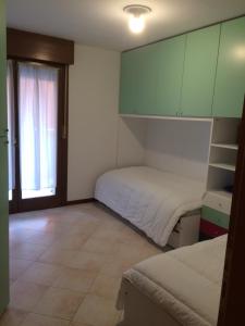 Habitación pequeña con 2 camas y ventana en Al Parco delle Rose, en Grado