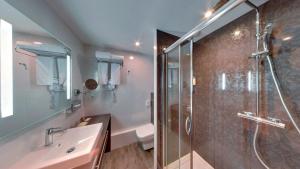 a bathroom with a shower and a sink at Best Western Hôtel d'Arc in Orléans