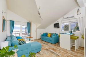 una sala de estar con muebles y ventanas de color azul. en Bayview Studio Apartment en Tivat