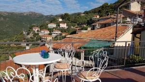 uma varanda com uma mesa e cadeiras num telhado em Liguria-Relax em Villa Faraldi