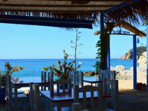 a table and chairs with the ocean in the background at APPARTEMENTS SOL y MAR - Cala Llevado 2 in Tossa de Mar