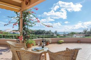 un patio con tavolo e sedie sul balcone. di Villa Betonia a Punta Prima