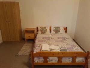 a bedroom with a wooden bed with two pillows at House lagonisi in Ormos Panagias
