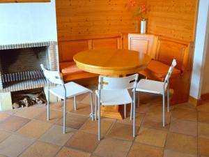 einen Holztisch und Stühle in einem Zimmer mit Kamin in der Unterkunft Appartement FRONT de MER in Tossa de Mar