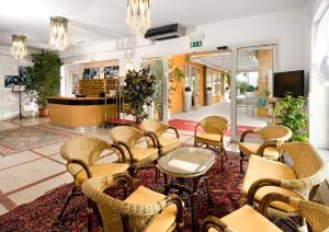 una sala d'attesa con sedie e tavoli nella hall di Hotel Giuliana a Cervia