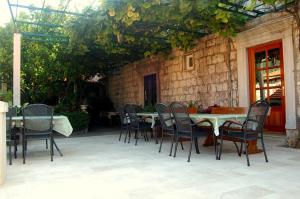 a patio with a table and chairs in a building at Villa Violić in Zaton