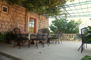 a patio with a table and chairs and a fence at Villa Violić in Zaton