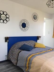 Au pied de la dune في سانجات: سرير مع اللوح الأمامي الأزرق في غرفة النوم