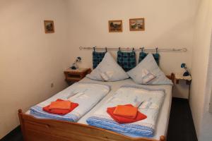 ein Schlafzimmer mit einem Bett mit orangefarbenen Handtüchern darauf in der Unterkunft Pension Haus Thies in Cochem
