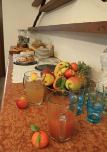 un montón de fruta en un mostrador con vasos de jugo en B&B Casa Zuane, en Rivoli Veronese