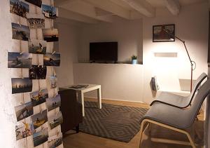 a room with a desk and a wall with pictures at Watermark Surf House in Espinho