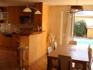 a kitchen and dining room with a wooden table at Villa Ardilla - Classée 3 étoiles -Grand confort et bien-être à proximité immédiate du centre du village et des commerces in Canet