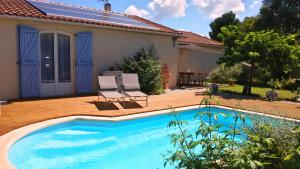 a swimming pool in front of a house at Villa Ardilla - Classée 3 étoiles -Grand confort et bien-être à proximité immédiate du centre du village et des commerces in Canet