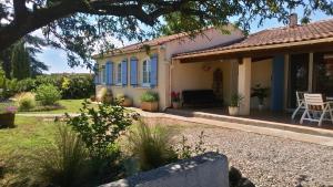 a house with blue windows and a patio at Villa Ardilla - Classée 3 étoiles -Grand confort et bien-être à proximité immédiate du centre du village et des commerces in Canet