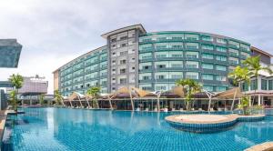 a hotel with a large swimming pool in front of a building at MBI Resort Danok in Sadao