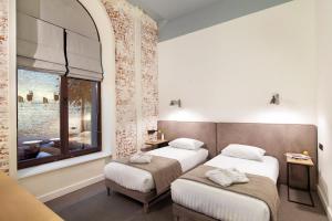 a hotel room with two beds and a window at FERENC Hotel & Restaurant in Lviv