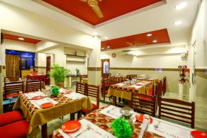 un comedor con mesas y sillas en un restaurante en Hotel Abi's Inn en Thanjāvūr