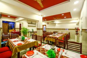 a dining room with tables and chairs in a restaurant at Hotel Abi's Inn in Thanjāvūr