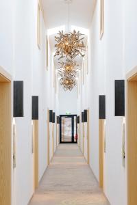 a hallway with white walls and a chandelier at Refugium Lindenwirt in Drachselsried