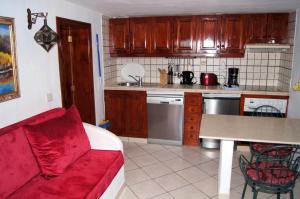 sala de estar con sofá rojo en la cocina en Castillo Lanzarote Villa Bailey - Luxury Villa - Pet friendly with heated Pool, en La Asomada