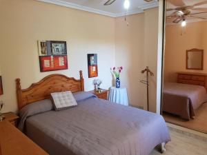 een slaapkamer met een bed en een tafel met bloemen erop bij Apartamento Aguadulce Moreno in Roquetas de Mar