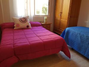 een slaapkamer met een roze bed en een blauwe deken bij Apartamento Aguadulce Moreno in Roquetas de Mar