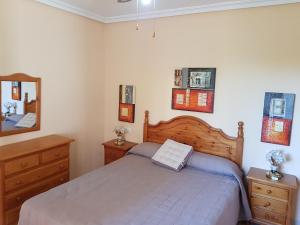 een slaapkamer met een bed, 2 dressoires en een spiegel bij Apartamento Aguadulce Moreno in Roquetas de Mar