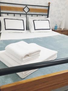 un letto con due asciugamani bianchi di Casa BeijoMar a Nazaré