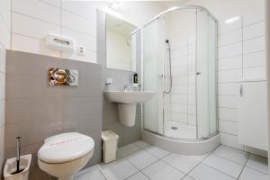 y baño con aseo, lavabo y ducha. en Apartmány Vera, en Bešeňová