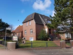Haus-Eilers-Borkum في بوركوم: منزل من الطوب مع علامة أمامه