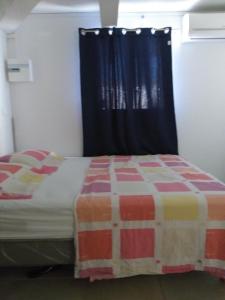 ein Schlafzimmer mit einem Bett mit einem schwarzen Vorhang in der Unterkunft TI PANNYE in Deshaies
