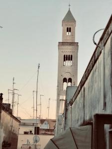 una torre alta con un reloj en la parte superior de un edificio en Appartamenti San Marco en Bari