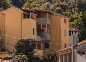 an apartment building on the side of a mountain at Apartments and rooms Roberto B. in Valun