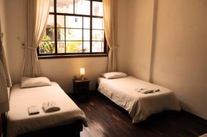 2 camas en una habitación con ventana en Arche Noah Boutique Hostel, en Bogotá