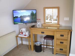 a dressing table with a mirror and a tv on a wall at Cashen Course House V31 RR40 in Ballybunion