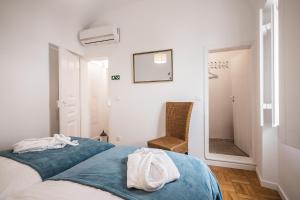a bedroom with a bed with blue sheets and a mirror at Casa dos Mouros in Évora